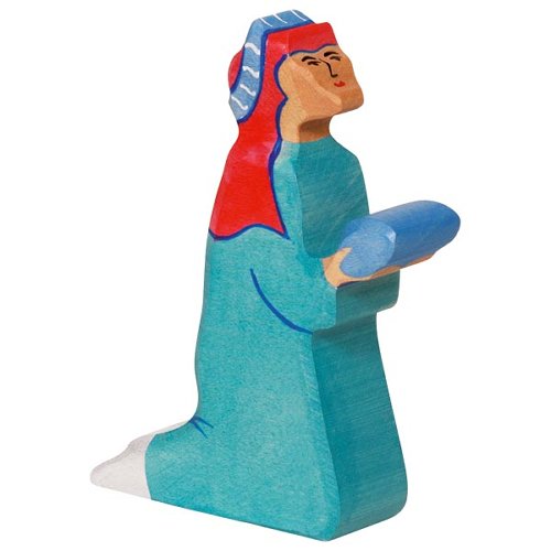 Wooden figurine of a person in teal clothing with a red head covering on a white background