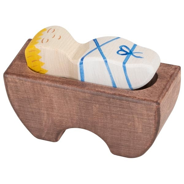 Wooden toy with a wrapped baby in a crib on a white background
