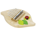 Wooden kalimba with ladybug and leaves on a white background