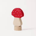 A small wooden toy mushroom with a red cap decorated with white spots, a light natural wood stem, and a round natural wood base, photographed on a clean white background.