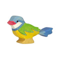 A wooden figure of a blue tit bird with green, yellow, and red coloring on a beige base.