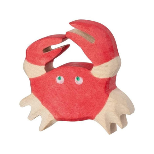 Red crab-shaped toy with green eyes on a white background made of wood